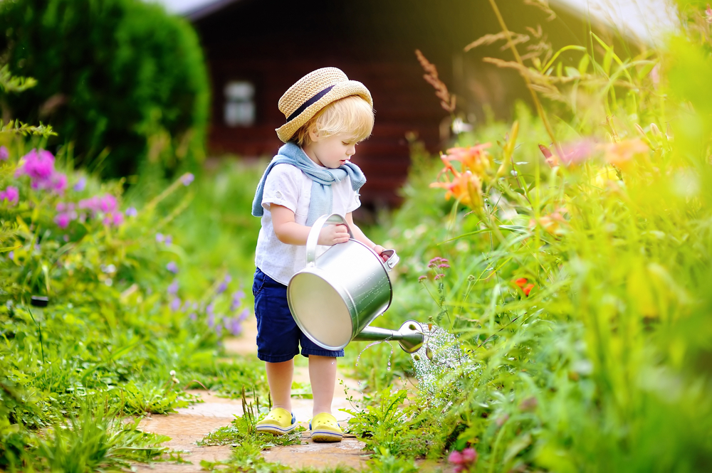 Enfant qui arrose un jardin